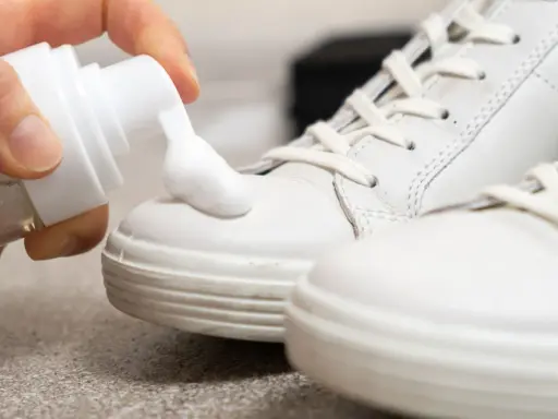 Schaum wird auf weiße Sneaker aufgetragen, um sie sauber zu machen.