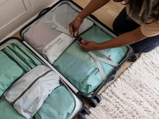 Frau packt ihren Koffer mit Packwürfeln. So packe ich meinen Koffer für die Reise, ordentlich und platzsparend.