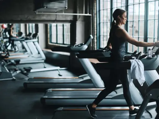 Frau läuft auf Laufband im Fitnessstudio. Ein Laufband bringt Ausdauer und Fitness.