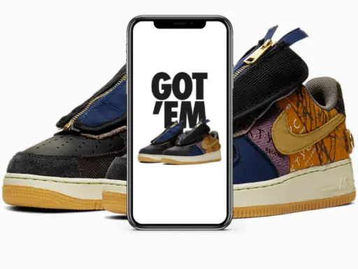 Ein Handy zeigt "GOT 'EM" über einem Paar Travis Scott Air Force 1. Das ist, was ist ein raffle, wenn man diese begehrten Sneaker ergattert!