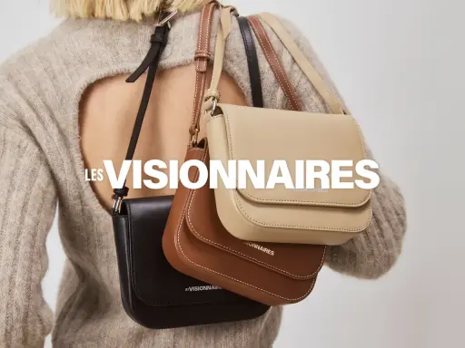 Drei Taschen in Schwarz, Braun und Beige hängen über der Schulter einer Person. LES VISIONNAIRES.