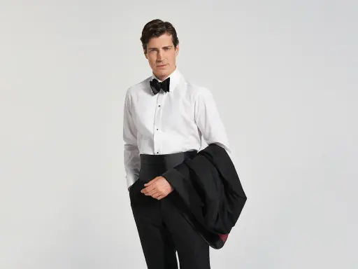 Mann im Smoking mit Fliege und Kummerbund, bereit für den black tie dresscode herren.