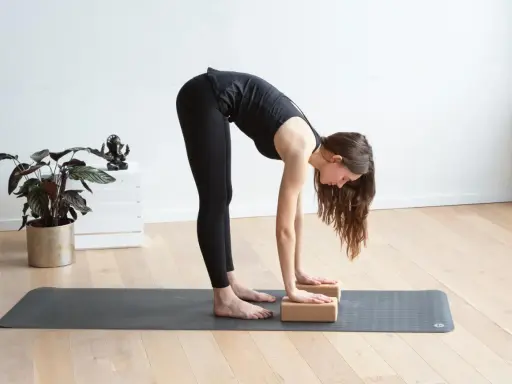 Frau macht Yoga mit Block, um ihre Dehnung zu vertiefen.