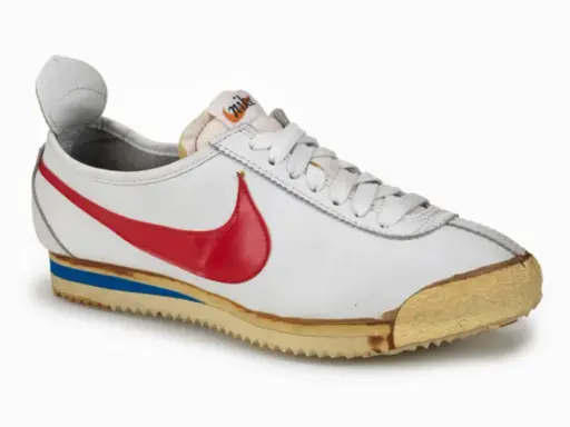 Der erste Nike Schuh von 1972, ein weißer Cortez mit rotem Swoosh und blauer Zwischensohle, ein Meilenstein des Sportschuhdesigns.