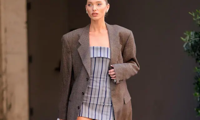 Frau im karierten Blazer und gestreiftem Kleid. Der Blazer muss dringend gewaschen werden, um den Fleck zu entfernen.