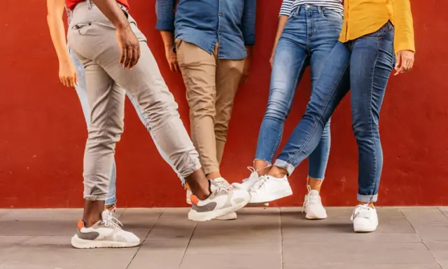 Vier Personen mit stylischen Sneakern stoßen ihre Füße aneinander. Perfekt für einen Sneaker-Blog!