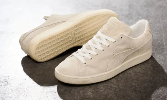 Zwei cremefarbene Puma Wildleder Sneaker, die zeigen, wie fallen Puma Schuhe aus: klassisch und bequem.