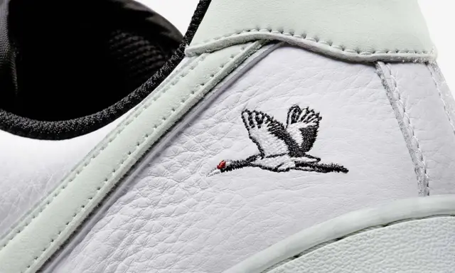 Detailaufnahme eines weißen Sneakers mit Stickerei eines Kranichs. Ein beliebter Schuh, der zu den meistverkauften Sneakern zählt.