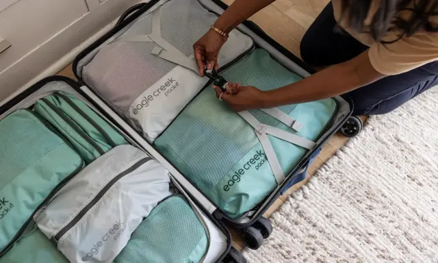 Frau packt ihren Koffer mit Packwürfeln. So packe ich meinen Koffer für die Reise, ordentlich und platzsparend.