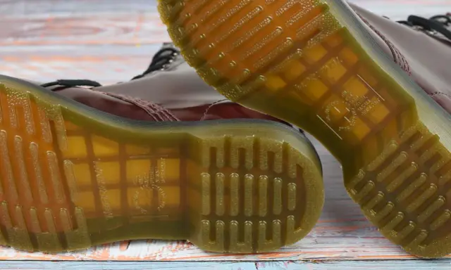 Die charakteristische, gelbe Naht und das Profil der **Dr. Martens Sohle original** sind auf dem Holzuntergrund zu sehen.