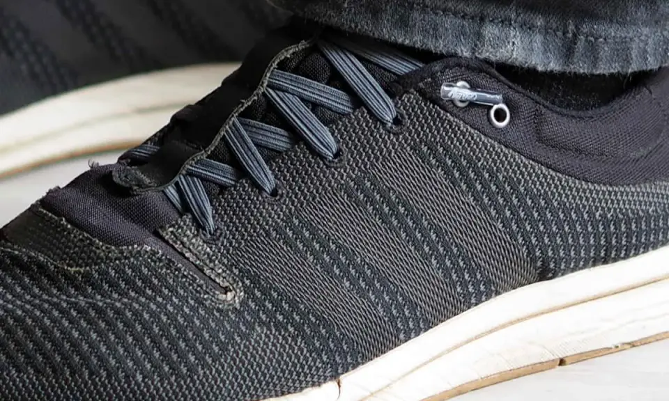 Schuhe binden ohne schleife: Schnürsenkel sind durch Ösen geführt und mit einem Stopper fixiert, was schnelles Anziehen ermöglicht.