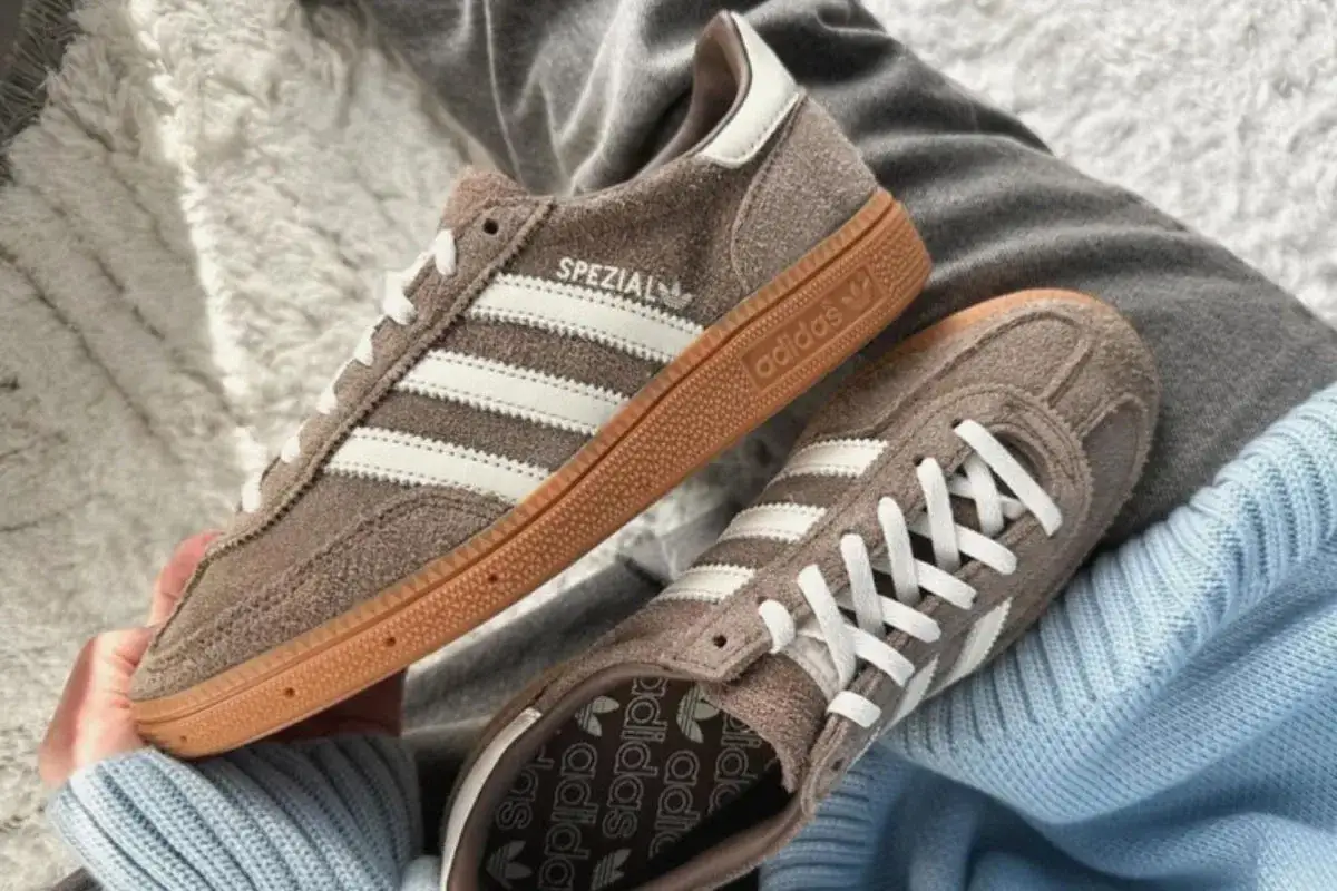 Braune Adidas Spezial Sneaker mit wei&szlig;en Streifen und Gummisohle. Sie fallen gr&ouml;&szlig;tenteils normal aus, aber manche empfehlen, eine halbe Nummer kleiner zu w&auml;hlen.