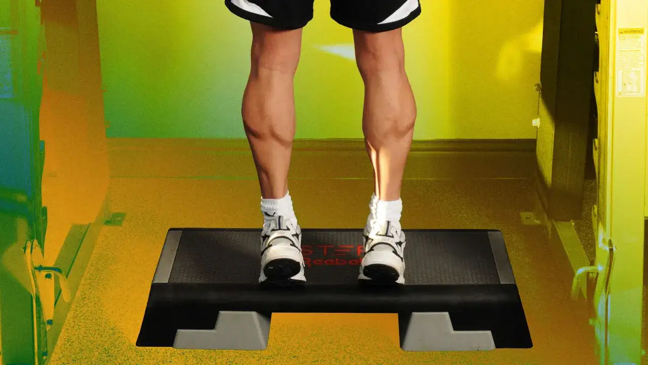 Mann trainiert seine Wadenmuskulatur auf einem Stepper. Die Beine sind stark definiert.