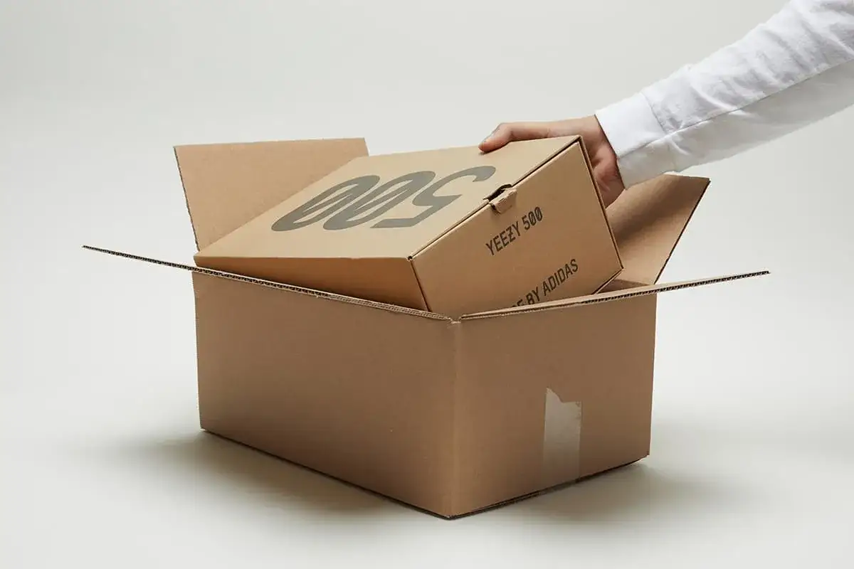 Ein Paket mit Yeezy 500 Schuhen wird ge&ouml;ffnet. Die Vorfreude auf die StockX Lieferzeit ist gro&szlig;.