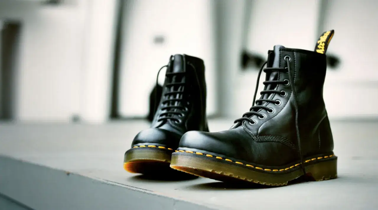 Schwarze Dr. Martens 1460 mit gelben Nähten und AirWair-Fersenschlaufe. Der Unterschied liegt in der Qualität und dem ikonischen Design.