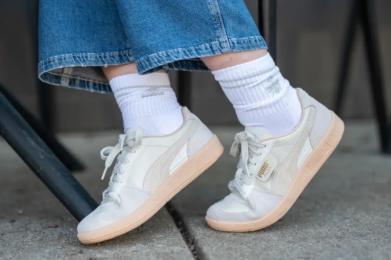 Weiße Socken im Sneaker-Trend mit hellen Puma-Schuhen und Jeans.