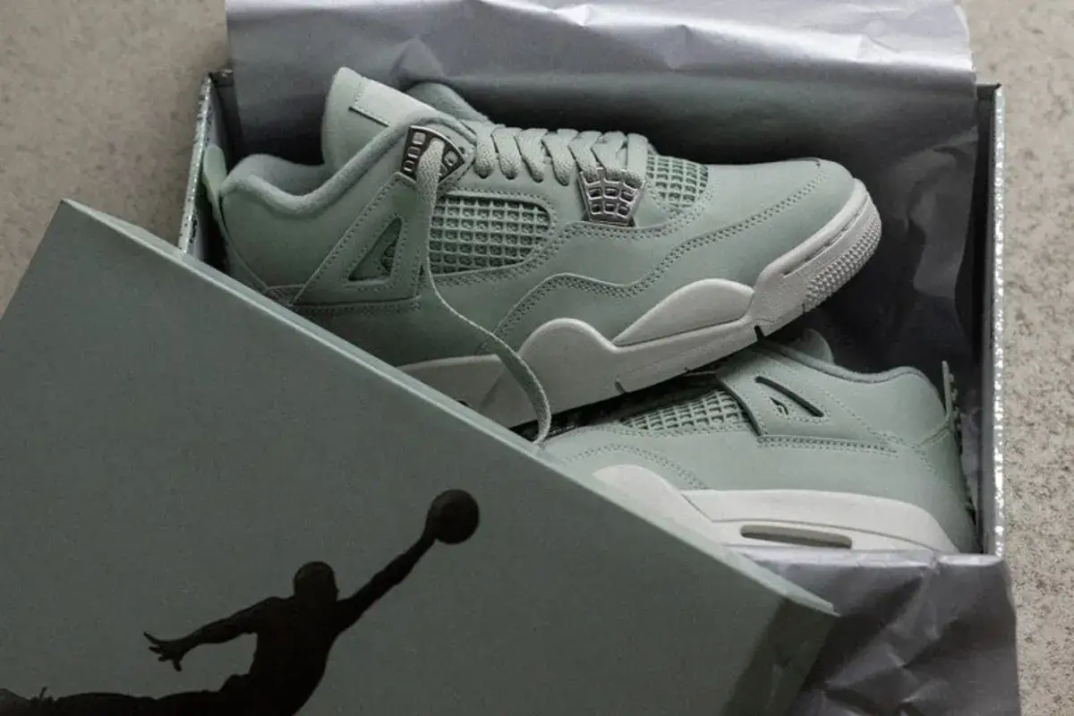 Jordan 4 Release Date: Hellgrüne Sneaker im Karton, bereit für den Launch.