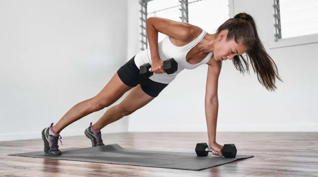 Frau macht einbeiniges Rudern im Plank-Position, ein intensives HIIT-Cardio-Training für den ganzen Körper.