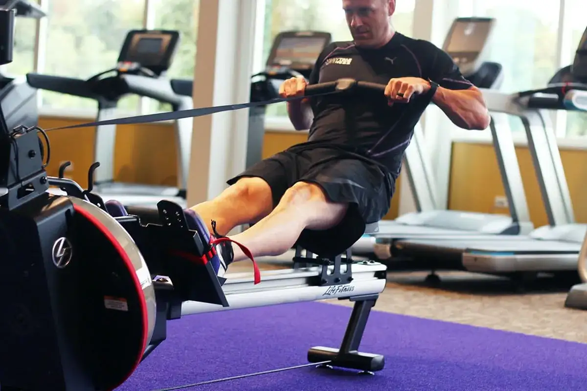 Mann auf Rudergerät, trainiert intensiv. Rudern ist ideal für den Kalorienverbrauch und ein Ganzkörper-Workout.