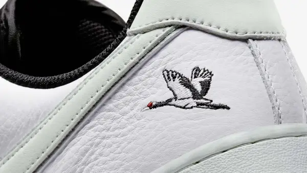 Detailaufnahme eines weißen Sneakers mit Stickerei eines Kranichs. Ein beliebter Schuh, der zu den meistverkauften Sneakern zählt.