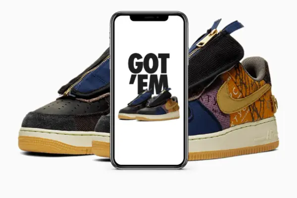Ein Handy zeigt "GOT 'EM" über einem Paar Travis Scott Air Force 1. Das ist, was ist ein raffle, wenn man diese begehrten Sneaker ergattert!